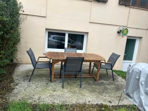 une table en bois avec quatre chaises et une fenêtre dans l'établissement Nuit à la campagne, à Assenoncourt