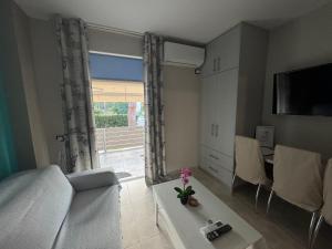 a living room with a white couch and a window at Bovis Apartments #2 in Porto Rafti