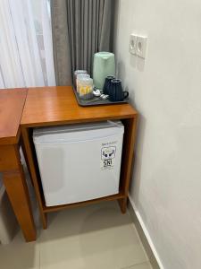 a small wooden table with a refrigerator under a table at Wonder Dive Bali Tulamben Villa's in Tulamben