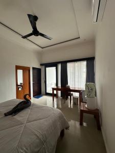 a bedroom with a bed and a desk with a chair at Wonder Dive Bali Tulamben Villa's in Tulamben +24 photos