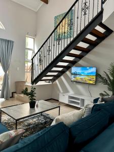 a living room with a blue couch and a staircase at The Great Escape in North Riding in Four Ways