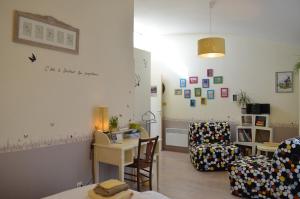 a living room with a couch and a table and a chair at Couette Et Cafe Crème in Le Coudray