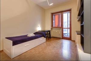 1 dormitorio con cama, mesa y ventana en MonteCucco, en Turín