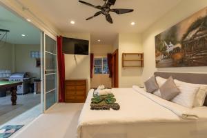 a bedroom with a bed and a ceiling fan at Karon Bliss: 4 Bedroom Haven in Karon Beach +91 photos