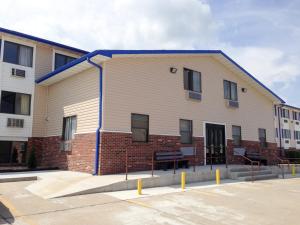 a large white building with a blue roof at Motel 6-Sedalia, MO in Sedalia