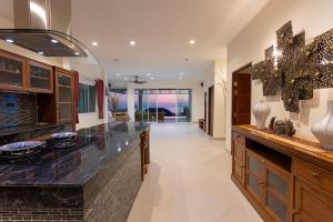 a large kitchen with a large black counter top at Karon Bliss: 4 Bedroom Haven in Karon Beach