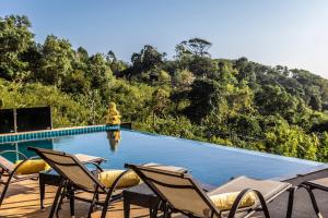 a swimming pool with chairs and a fountain at Karon Bliss: 4 Bedroom Haven in Karon Beach