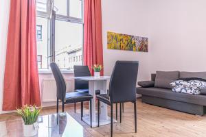 een woonkamer met een tafel, stoelen en een bank bij Large 5BR Shared Apt in Central Location, Near Augarten in Wenen +62 foto's