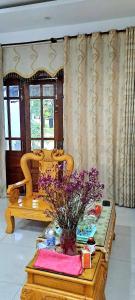 Una sala de estar con una mesa con flores. en Clara home, en Da Nang