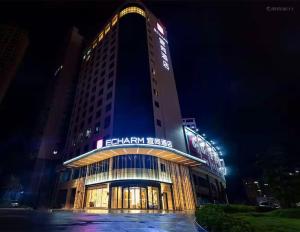 玉林Yishang Hotel Yulin Rongxian Rongzhou Commercial Plaza Branch的一座高大的建筑,晚上有钟