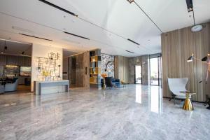 玉林Yishang Hotel Yulin Rongxian Rongzhou Commercial Plaza Branch的大型客房,设有配备桌椅的大堂。