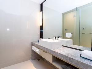 玉林Yishang Hotel Yulin Rongxian Rongzhou Commercial Plaza Branch的带水槽和镜子的浴室