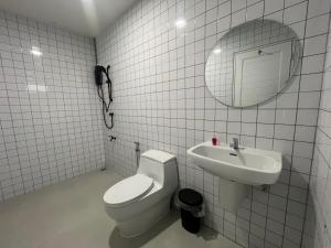 Ban Chuk KumThe Duck House的白色瓷砖浴室设有卫生间和水槽