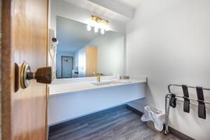 a bathroom with a sink and a mirror at Blue Horse Motel in Beiseker +17 photos