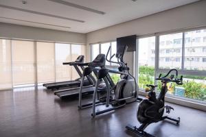 a gym with several cardio bikes in a room with windows at DaLei 3-103 Sleeps 6pax at Marina Spatial Condominium in Dumaguete City in Dumaguete
