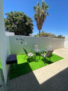 a table and chairs on a patio with grass at Sunbird self-catering B in Windhoek