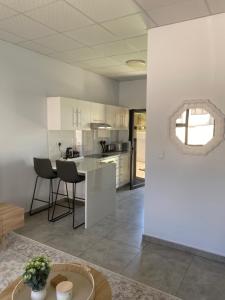 a kitchen with white cabinets and a table and chairs at Sunbird self-catering B in Windhoek
