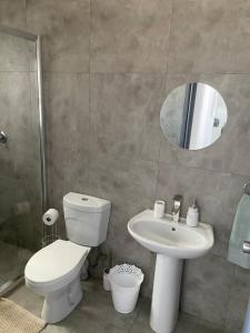 a bathroom with a toilet and a sink and a mirror at Sunbird self-catering B in Windhoek +11 photos
