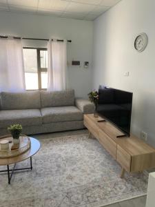 a living room with a couch and a flat screen tv at Sunbird self-catering B in Windhoek