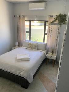 a bedroom with a large bed with a window at Sunbird self-catering B in Windhoek