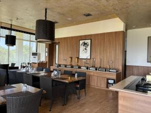 ein Esszimmer mit Holzwänden und Tischen und Stühlen in der Unterkunft STUDIO APARTMENT - TARUDHAN VALLEY GOLF RESORT Gurgaon in Gurgaon