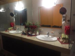 eine Badezimmertheke mit zwei Waschbecken und zwei Spiegeln in der Unterkunft STUDIO APARTMENT - TARUDHAN VALLEY GOLF RESORT Gurgaon in Gurgaon + 9 Fotos