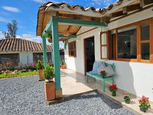 ein Haus mit einer blauen Bank auf einer Terrasse in der Unterkunft Cabaña San Miguel Arcangel in Villa de Leyva