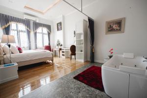 a bedroom with a bed and a bathroom with a tub at Banbua Grand Udon in Udon Thani +63 photos