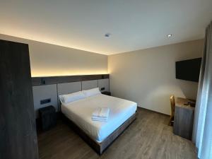 a bedroom with a bed and a flat screen tv at HOTEL RURAL FINCA LA DESA in Miajadas
