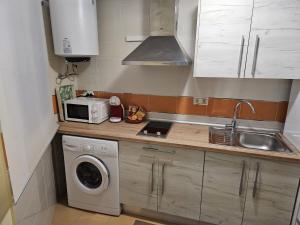 a small kitchen with a washing machine and a microwave at Carnaval 16 in Isla Cristina