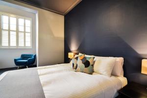 a bedroom with a bed and a blue wall at Hotel Canobolas in Orange