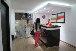 a woman standing at a cash register in a store at Hotel Plaza Roma in Ríohacha