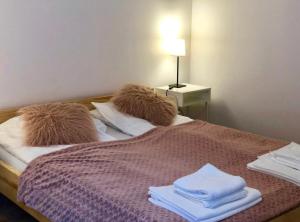 Una cama con toallas y una lámpara. en Apartament Ryneczek Bieszczad, en Ustrzyki Dolne