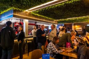 Un gruppo di persone che si aggirano intorno a un bar di Apart Hôtel des Cols a Bordères-Louron