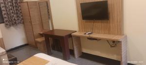 a room with a desk and a tv on a wall at Hotel nav bharath residency in Hyderabad