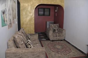 een woonkamer met twee banken en een tapijt bij Afrika Nomades in Abidjan