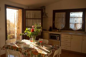 a kitchen with a table with a vase of flowers on it at Villa Blick in Guardistallo +23 photos
