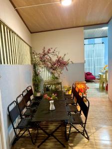 a table with chairs and a vase of flowers on it at Rose's House in Da Lat