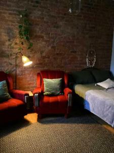 a bedroom with a bed and a couch and a chair at Hygge Home with free parking - Boho style apartment in Tartu