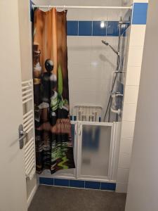 a shower stall with a shower curtain in a bathroom at Appart City Borderouge parking in Toulouse