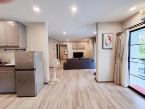 a kitchen with a refrigerator and a living room at Title Residencies Naiyang 2 Bedrooms PoolAccess in Nai Yang Beach