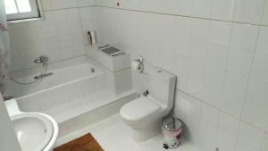 a white bathroom with a toilet and a sink at Villa Maira 2, Amazing Family apartment, 3 bedrooms, Swimming Pool, 150m to beach in Perea +18 photos