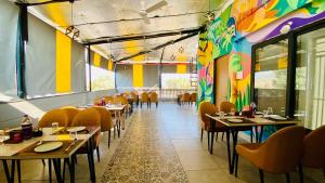 a dining room with tables and chairs and colorful walls at The Shankara View in Godarpura