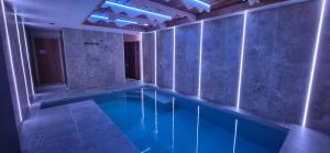 a swimming pool with blue lights in a room at L'Or du Lac in Gérardmer