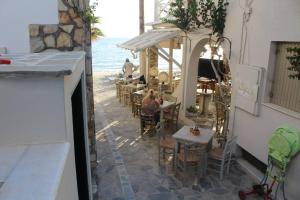 a restaurant with tables and chairs on the beach at Theofanis on the beach in Agia Anna Naxos