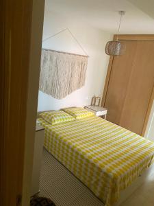 a bedroom with a yellow and white checkered bed at Acogedor apartamento con terraza in Cedeira