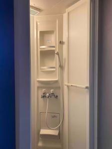 ニセコ町にあるCasa Bell Cabin Nisekoの白い冷蔵庫(シャワー付)が備わる客室です。