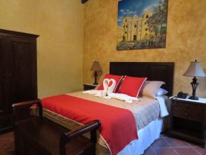 Un dormitorio con una cama con dos cisnes. en Casa Buena Vista, en Antigua Guatemala