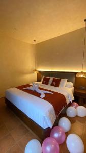 JetisにあるAllure Villa Yogyakartaのベッドルーム1室(ピンクと白の風船が備わるベッド1台付)