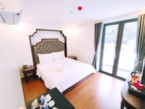 Postel nebo postele na pokoji v ubytování Royal Hotel Trâu Quỳ